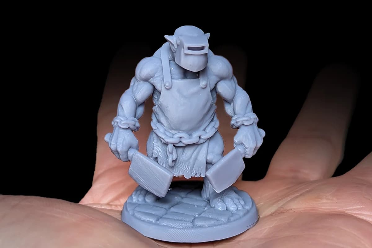 Physical resin miniature standing on a tabletop surface