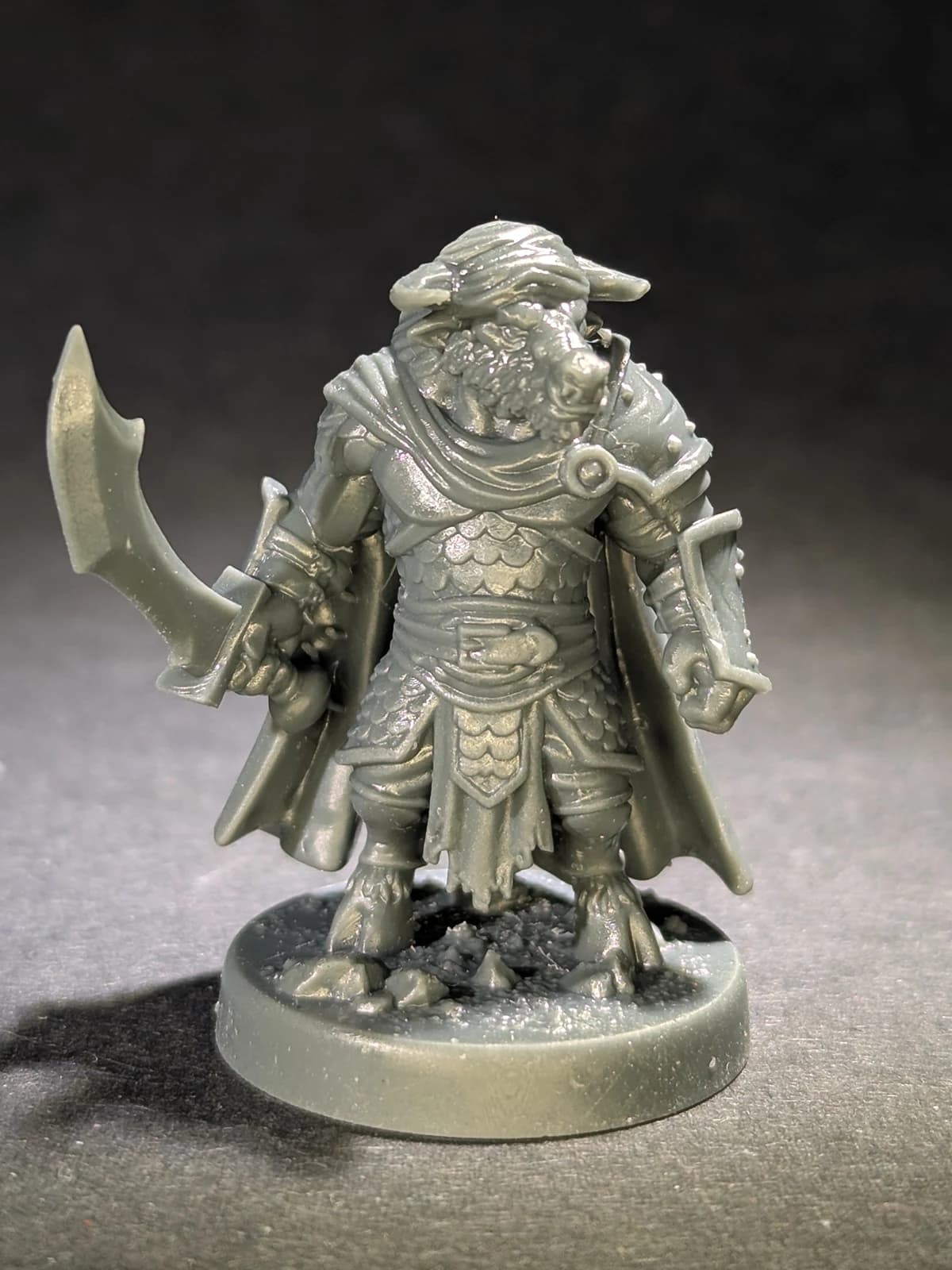 Unpainted resin bull warrior miniature with a curved sword on a round base